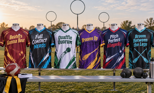 Six jerseys hanging on a rack at a turf field, printed with team names